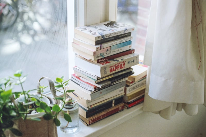 Books stacked on a window ledge
